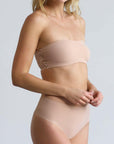A woman wearing a bandeau in nude.